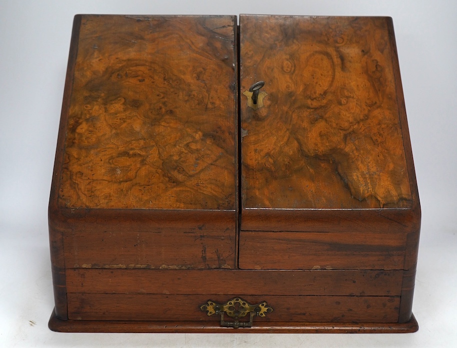 A Victorian burr walnut stationery rack, with two glass inkwells and partial label to the interior, with key, 37cm wide. Condition - fair